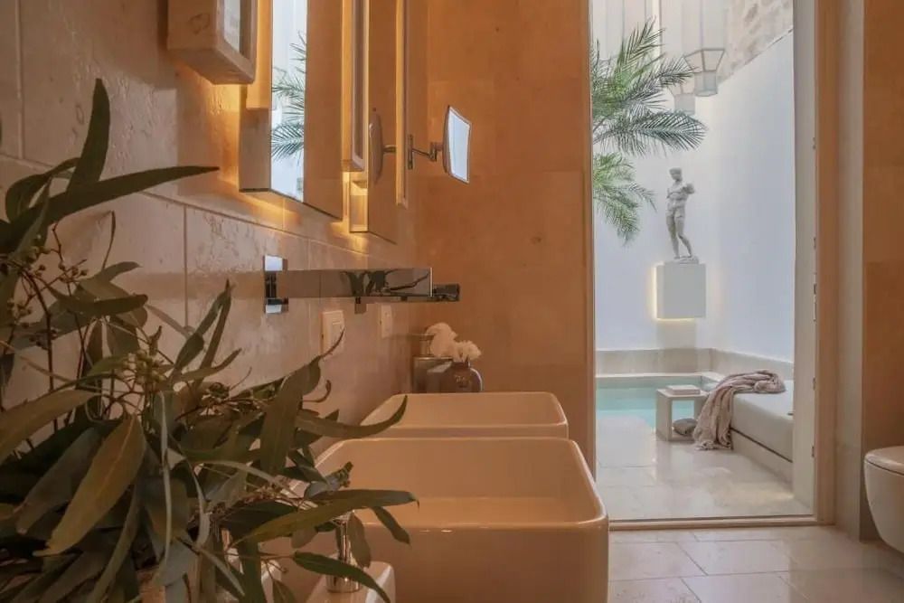 Blick aus dem Badezimmer auf privaten Innenhof mit Pool und Dekoration