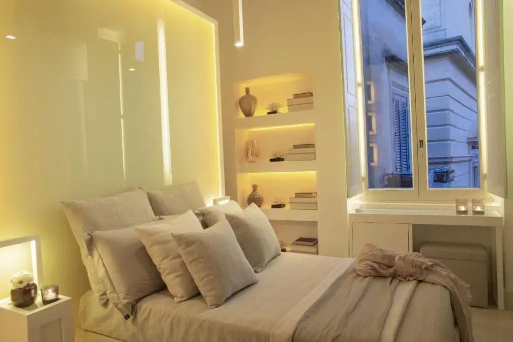 Hell und freundlich gestaltetes Doppelzimmer mit dekorativen Regalen und großen Fenstern.