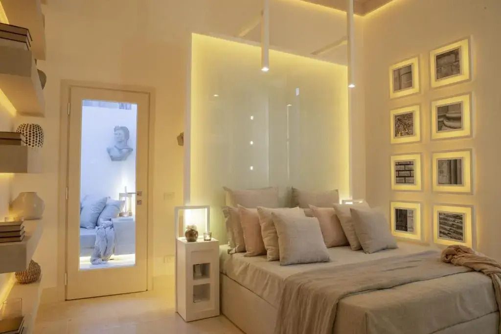 Geschmackvoll gestaltetes Hotelzimmer mit weichen Kissen und moderner Wandbeleuchtung.
