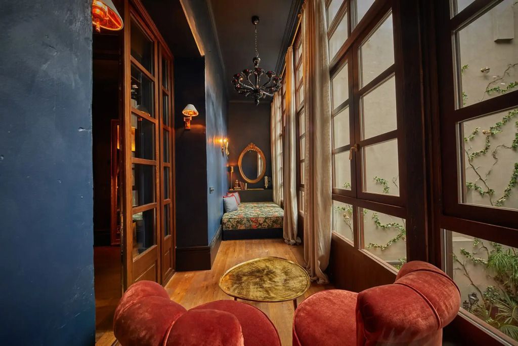 Stilvolle Suite mit großem Fenster und charmantem Sitzbereich