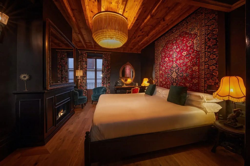 Luxuriöse Suite mit Doppelbett, Teppichwand und edler Beleuchtung