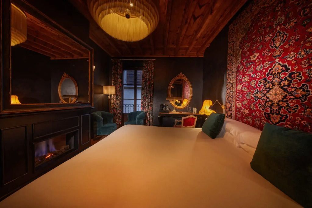 Geräumiges Schlafzimmer mit großem Bett, Kamin und stilvollem Spiegel