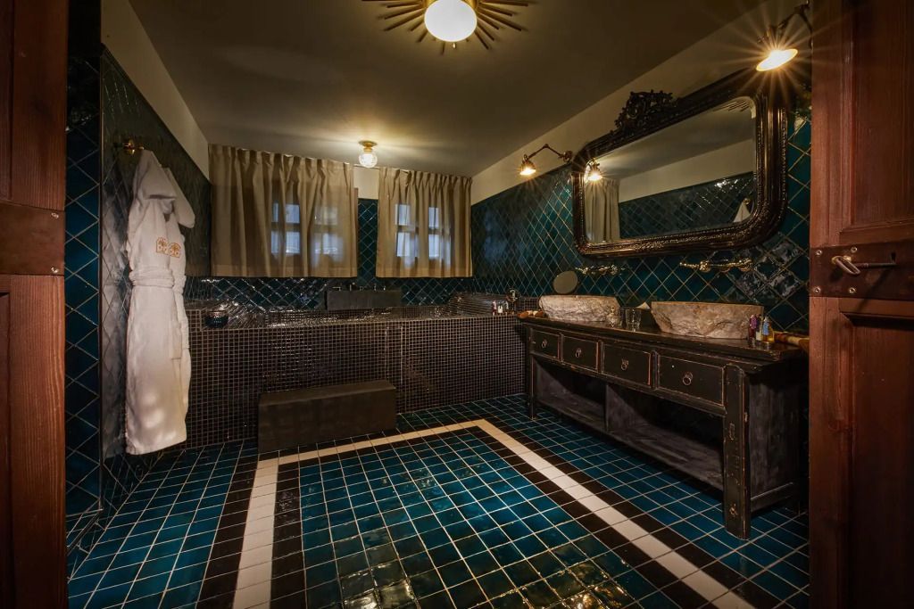 Modernes Badezimmer mit blauen Fliesen, Doppelwaschbecken und stilvollem Spiegel
