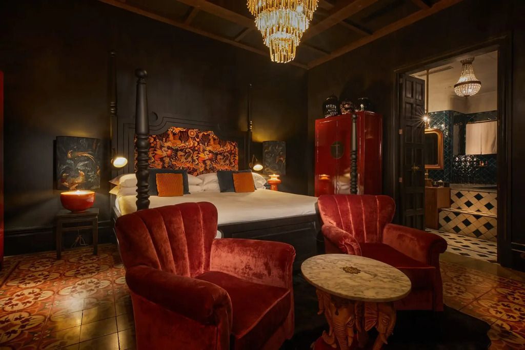 Luxuriöse Suite mit prächtigem Kronleuchter und roten Polstersesseln