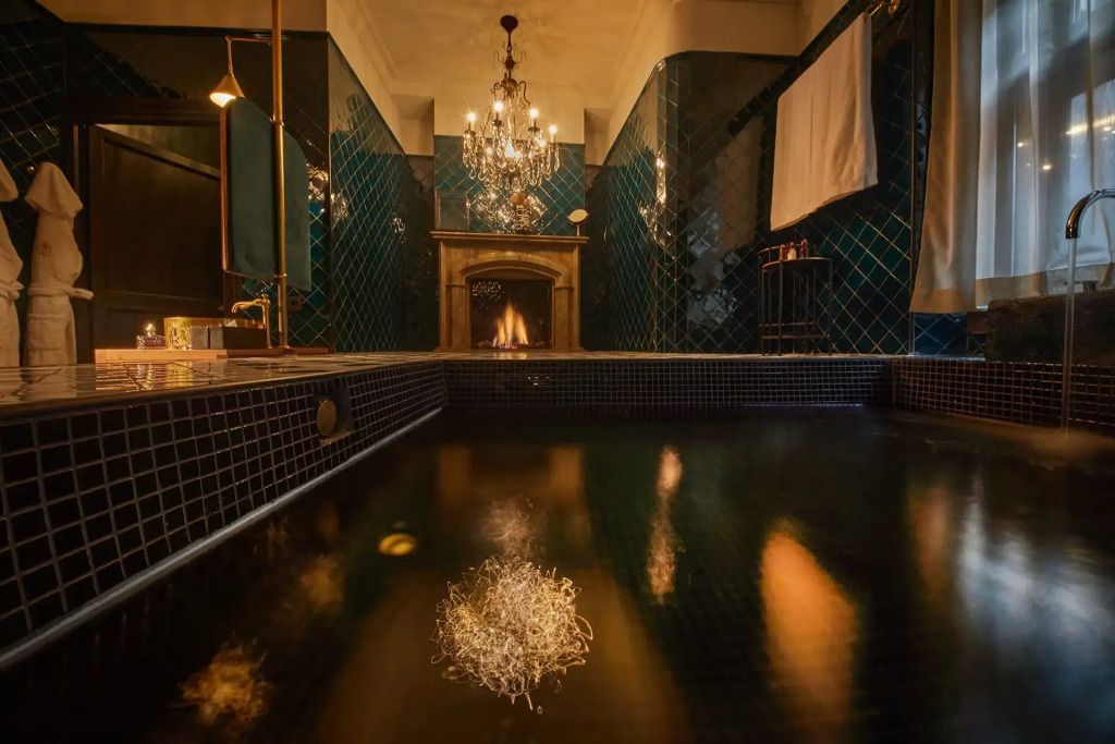 Elegantes Badezimmer mit dunklen Fliesen und hellem Kronleuchter