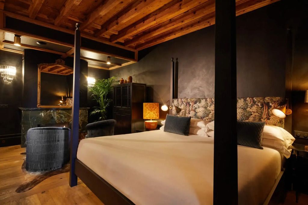 Elegantes Schlafzimmer mit Doppelbett, Holzbalkendecke, stilvollen Möbeln und sanfter Beleuchtung