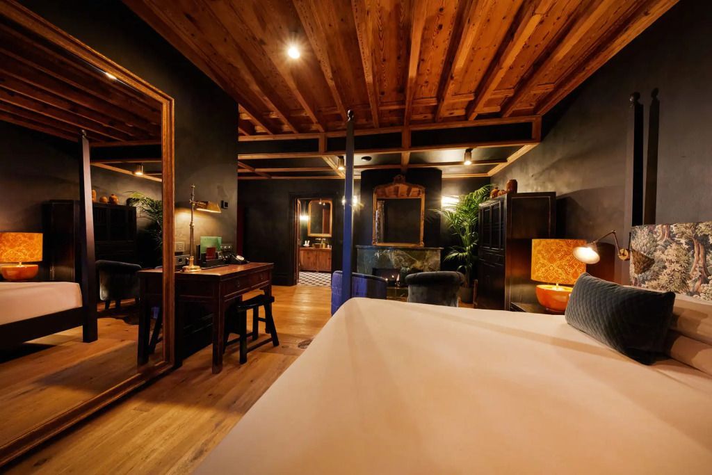 Luxuriöses Zimmer mit Holzbalkendecke, großem Spiegel und edler Einrichtung