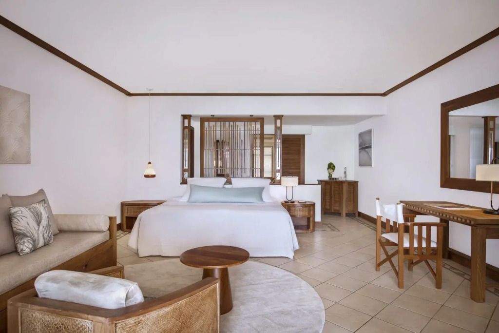 Geräumiges Schlafzimmer in der Junior-Suite am Strand mit heller Holzausstattung und Sitzbereich