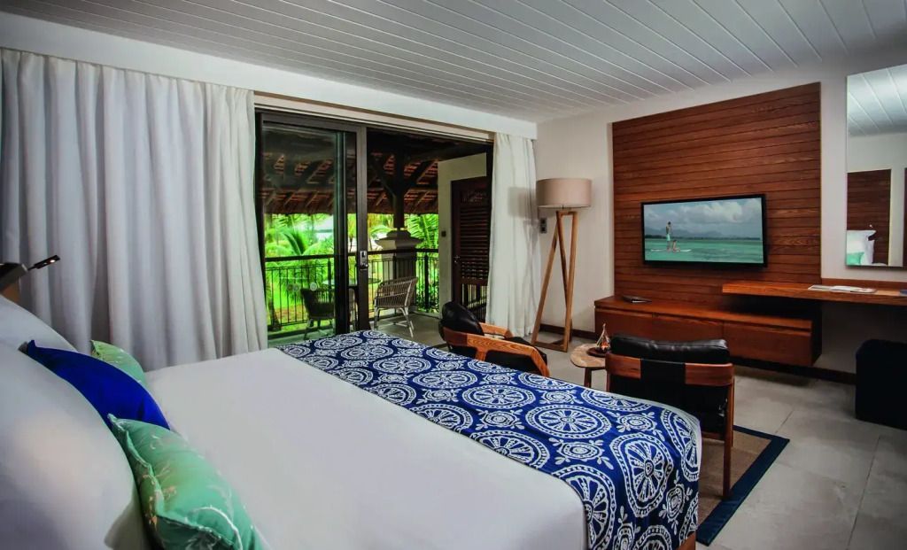 Geräumiges Zimmer mit Balkonzugang und Blick auf tropische Vegetation
