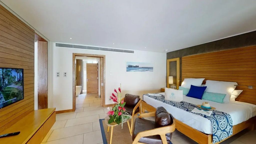 Helles Zimmer mit großem Doppelbett auf Holzboden und modernen Möbeln