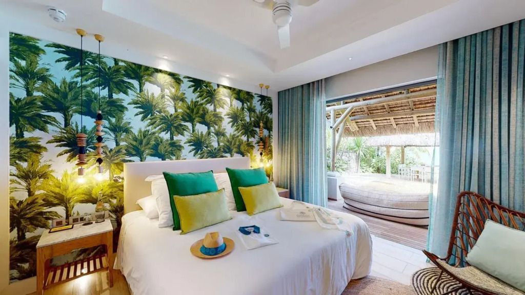 Schlafzimmer in der Paradis Villa mit tropischen Tapeten und Blick auf die Terrasse