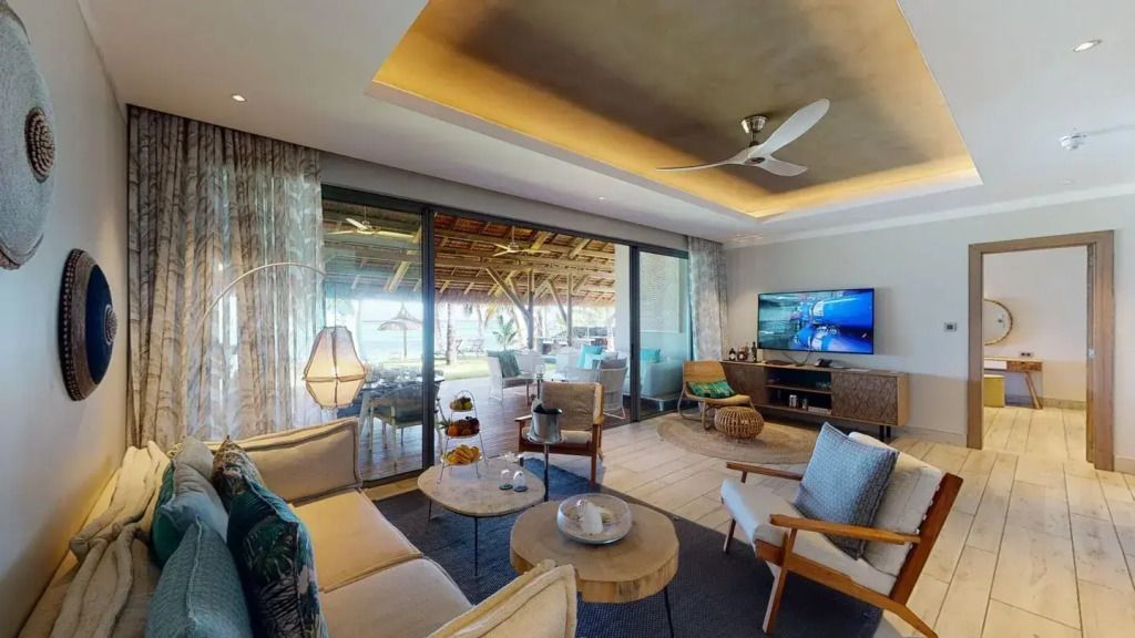 Wohnzimmer der Paradis Villa mit bequemen Sitzmöglichkeiten und Terrassenblick