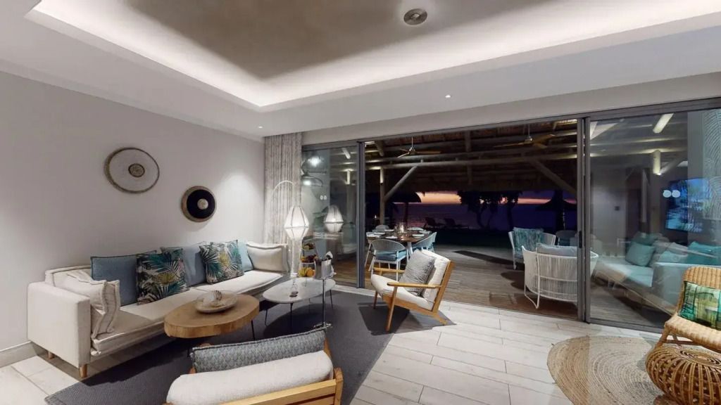 Elegante Lounge der Paradis Villa mit Terrasse und Blick auf das Meer bei Sonnenuntergang