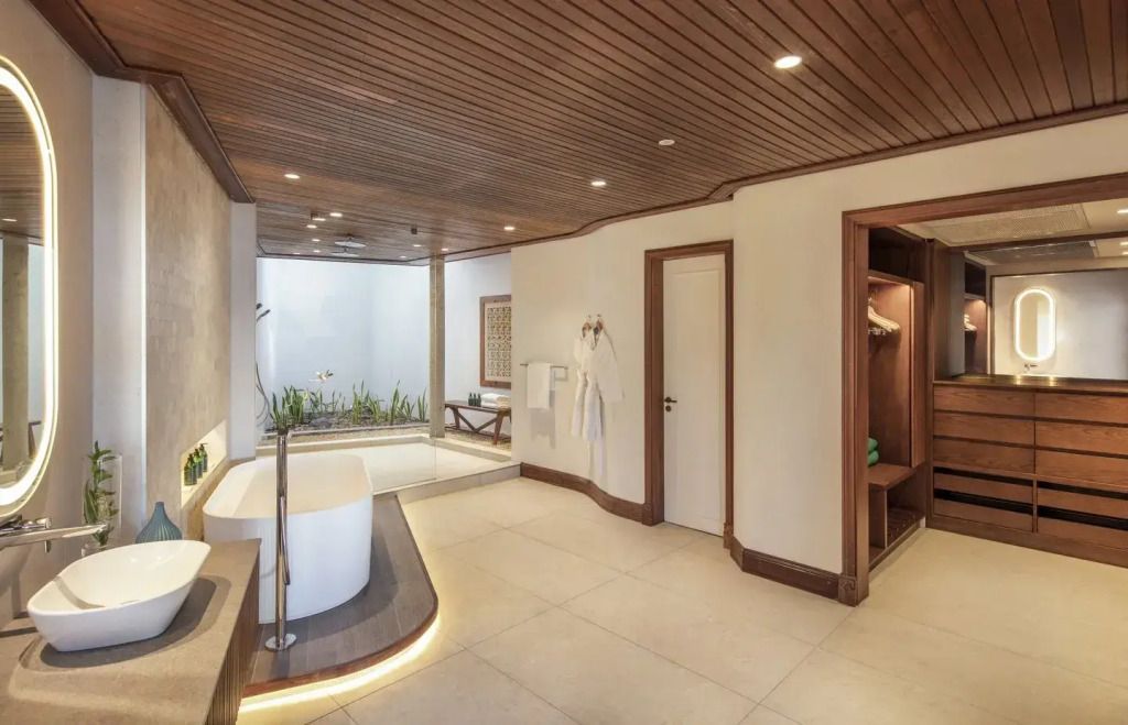 Geräumiges Badezimmer mit freistehender Badewanne und Blick auf den Innenhof