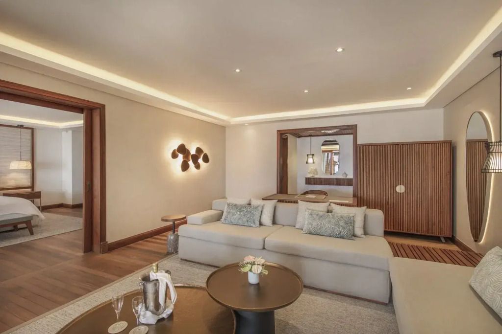 Wohnbereich der Suite mit komfortablem Sofa und dekorativer Beleuchtung