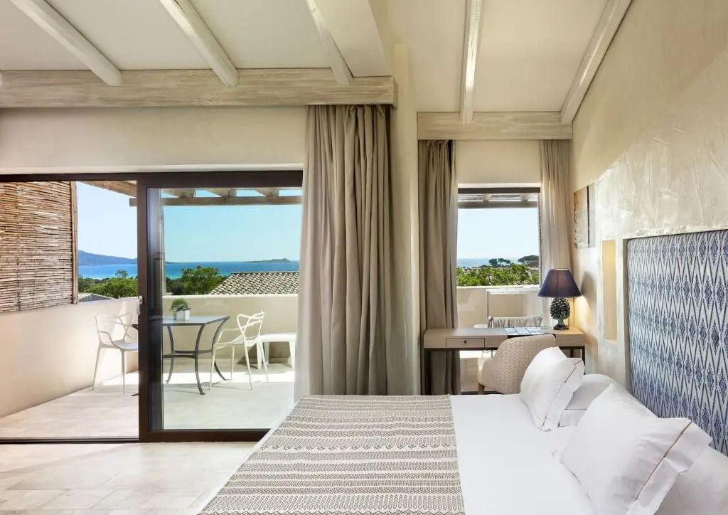 Helles Schlafzimmer mit großen Fenstern und Meerblick in einer Junior-Suite