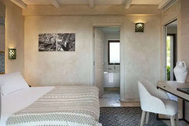 Schlafbereich in der Maddalena Suite mit modernem Dekor und Zugang zum Badezimmer