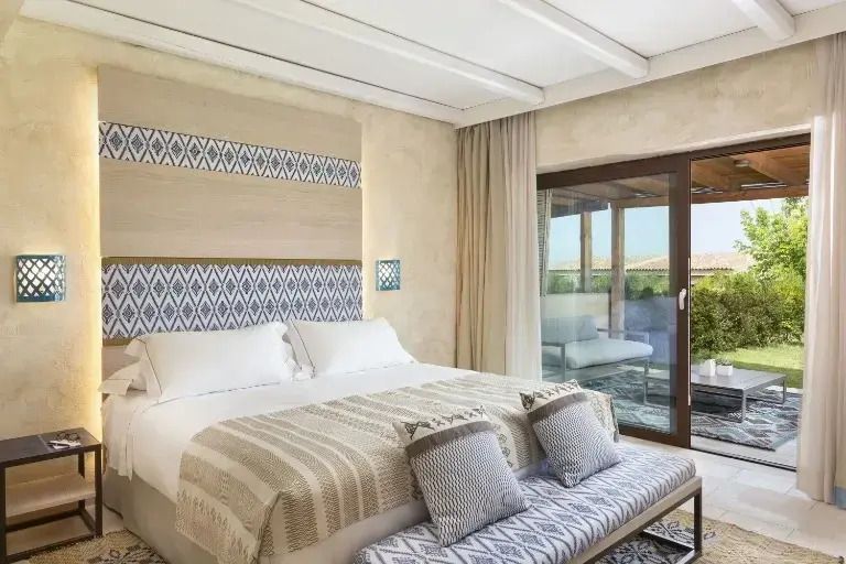 Elegantes Schlafzimmer mit großem Bett und natürlicher Beleuchtung in Suite.