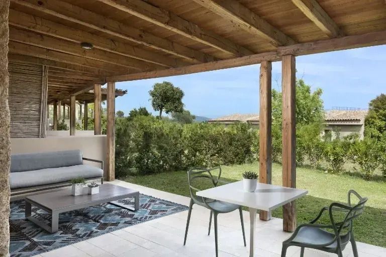 Überdachte Terrasse mit Sitzgarnitur und Blick auf den Garten.
