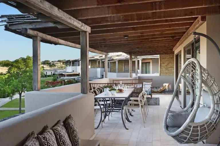 Überdachte Terrasse mit Esstisch und Sitzgelegenheiten im Freien