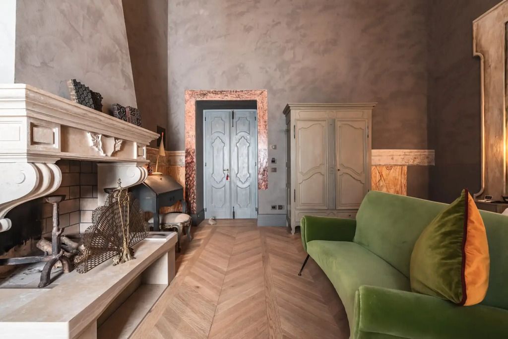 Stilvolle Suite mit grünem Sofa, Kamin und Holzdetails