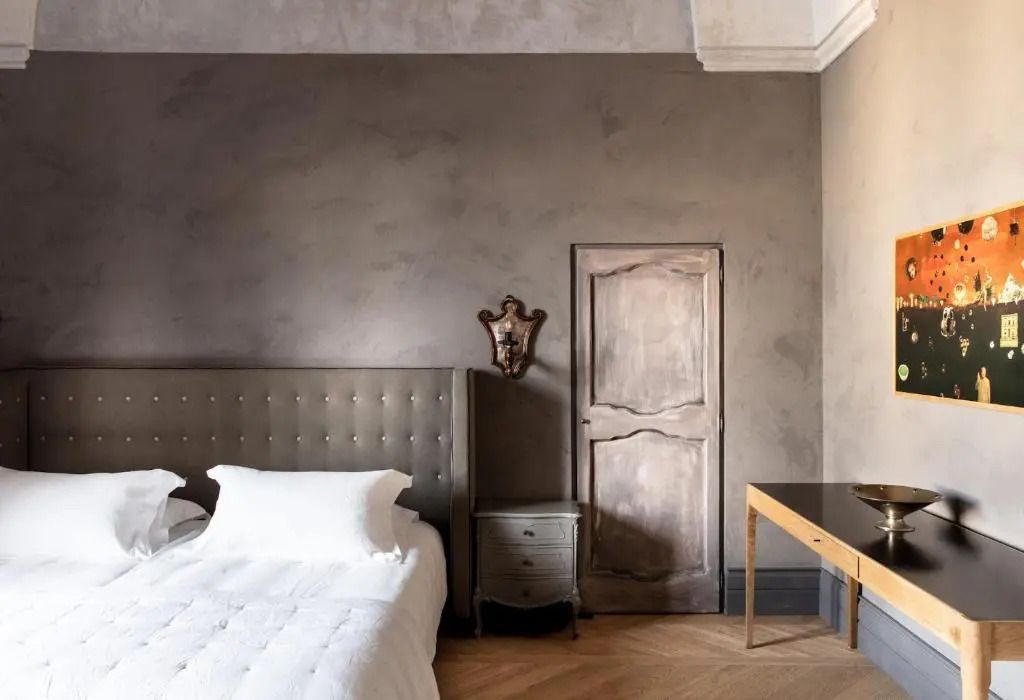 Harmonisches Schlafzimmerdesign mit gepolstertem Bett und antikem Mobiliar