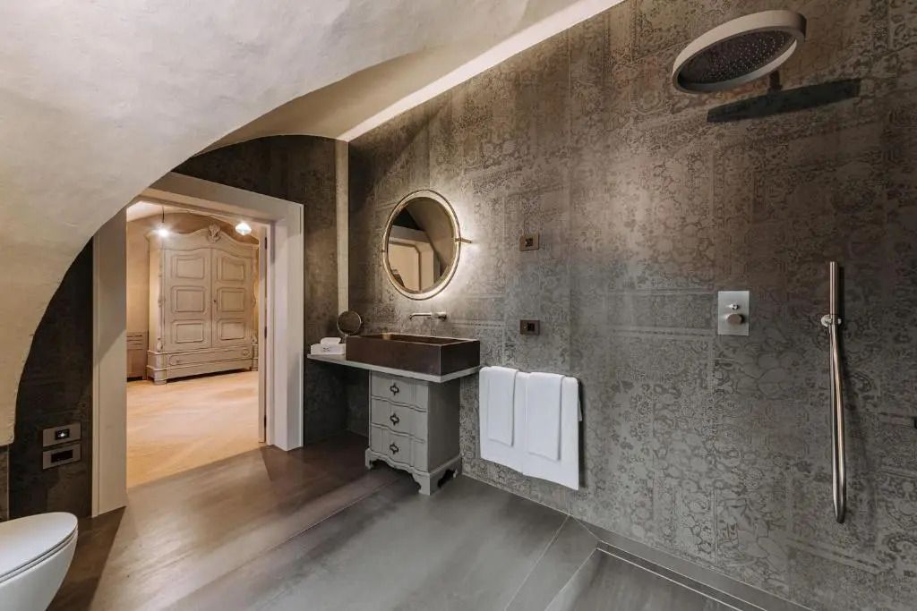 Modernes Badezimmer mit Design-Elementen und großem Rundspiegel im Paragon 700 Hotel