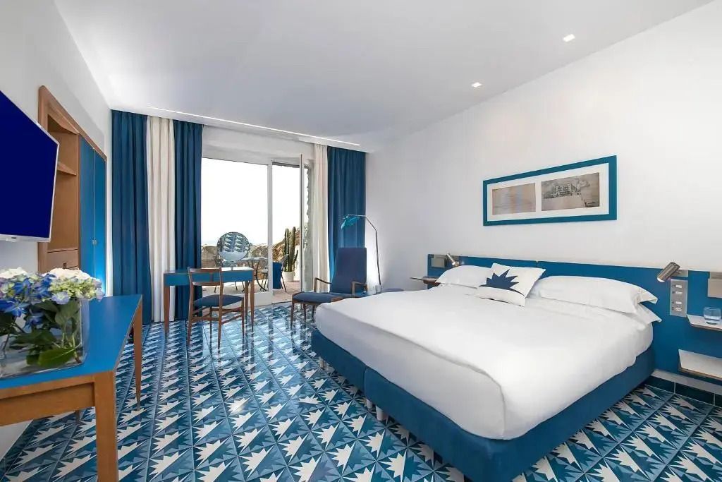 Geräumiges Zimmer mit Doppelbett und direktem Meerblick durch Balkontüren