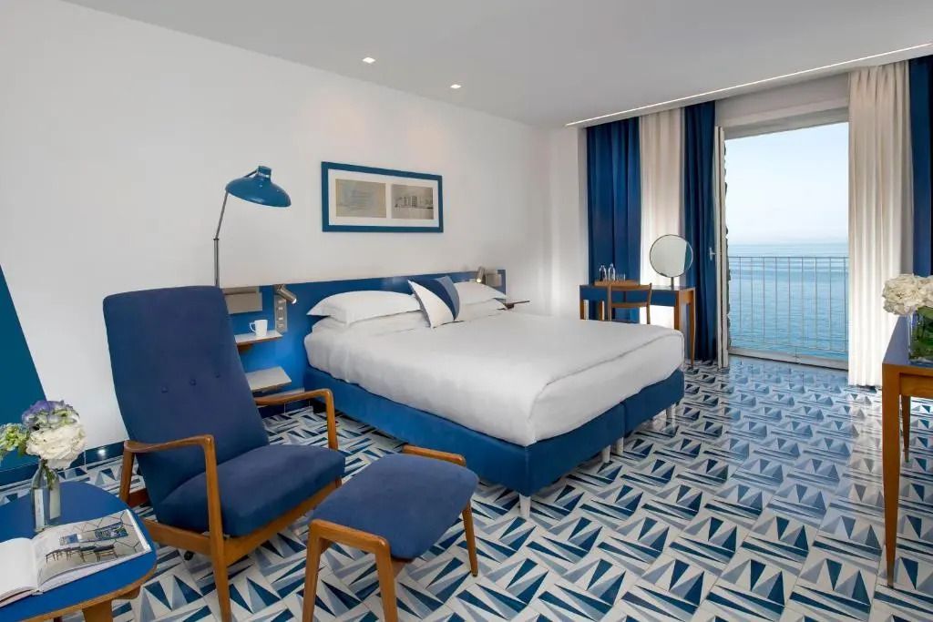 Superior Doppelzimmer mit blau-weißem Dekor und Meerblick vom Balkon