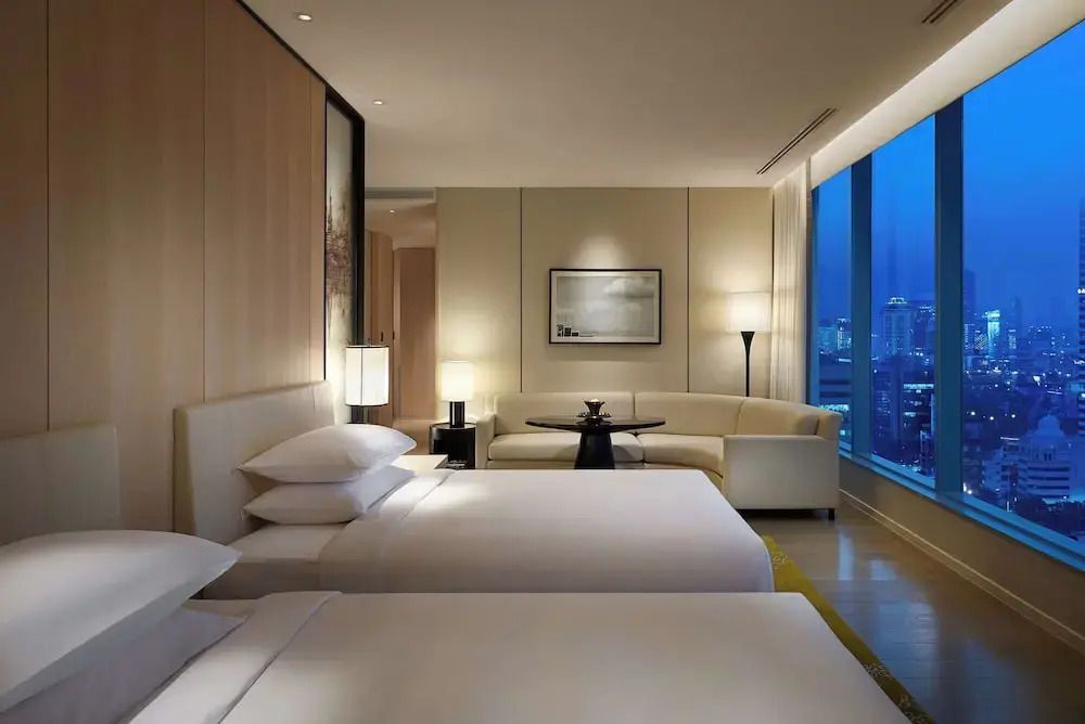 Beleuchtetes Deluxe Doppelzimmer abends mit gemütlichem Ambiente und Stadtblick