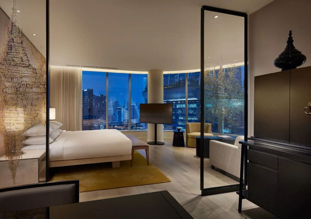 Großzügiges Doppelzimmer mit Panoramafenstern und nächtlichem Stadtpanorama