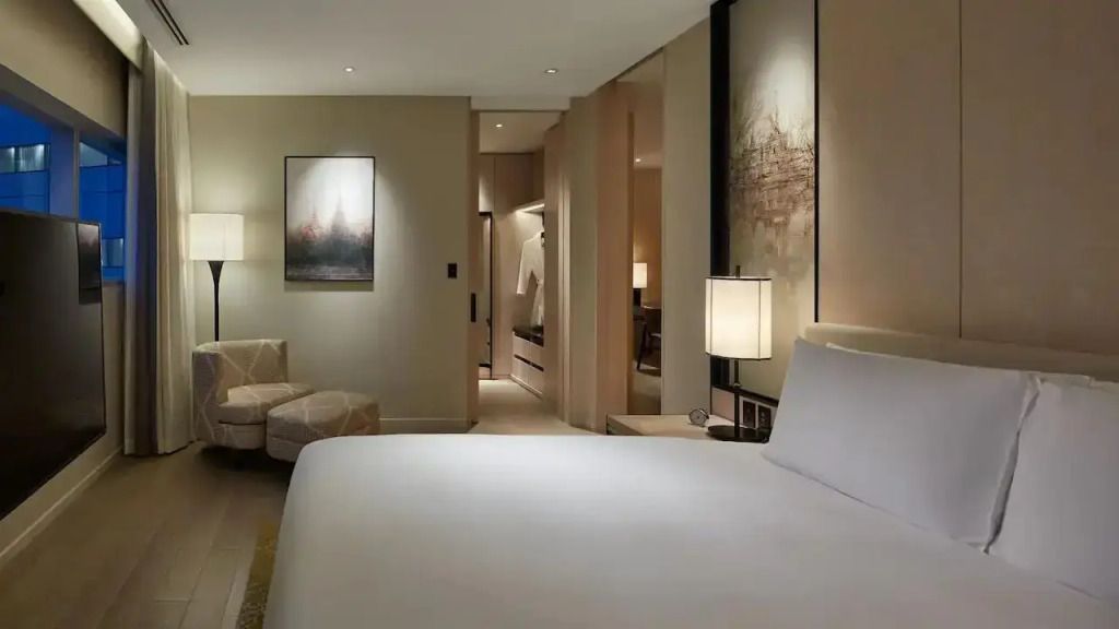 Elegante Suite mit Kingsize-Bett, dezente Beleuchtung und Kunst an den Wänden
