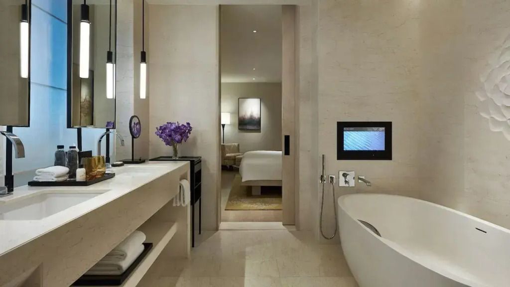 Luxuriöses Badezimmer mit Badewanne, integrierten Lichtern und TV