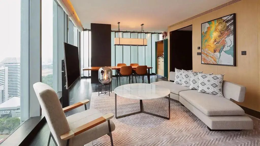 Elegante Suite mit gemütlichem Wohnzimmer und großem Fenster mit Stadtblick.