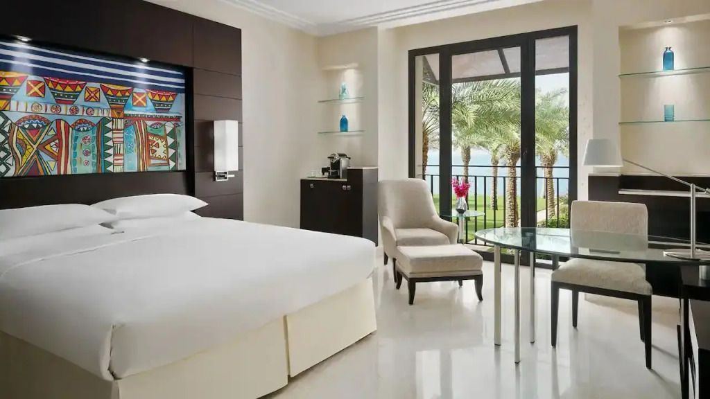 Helles Zimmer mit Doppelbett und Balkon mit Blick auf Palmen und Meer im Park Hyatt Jeddah