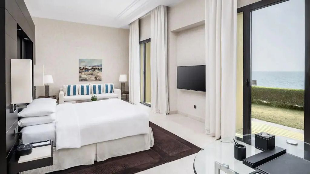Elegantes Hotelzimmer mit Doppelbett und moderner Einrichtung in hellen Tönen