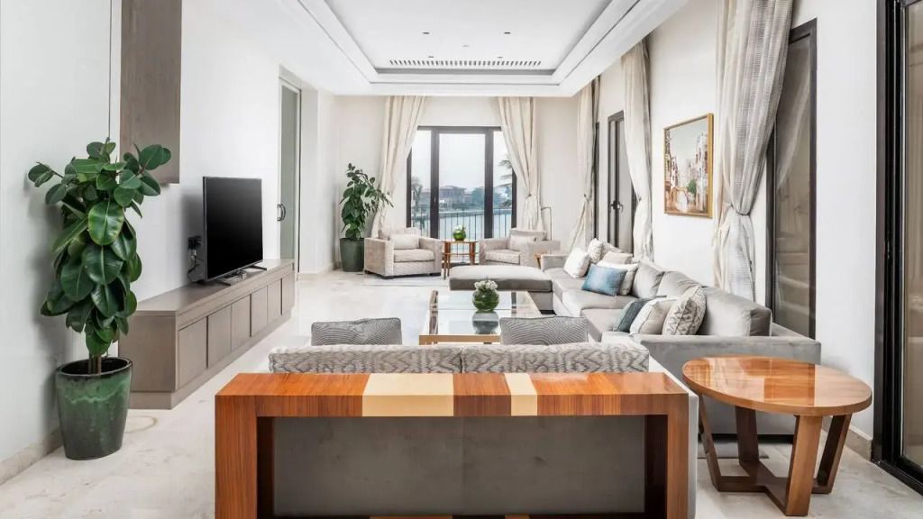 Geräumiges Wohnzimmer mit großen Fenstern und Blick auf das Wasser