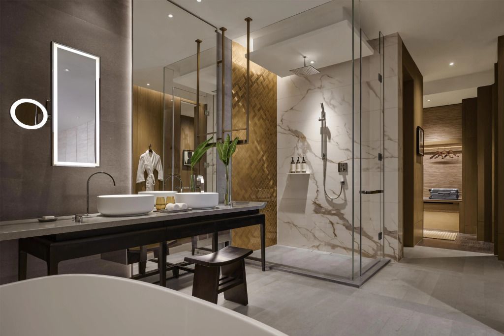 Elegantes Badezimmer mit Glasdusche und Marmorakzenten im Hotel