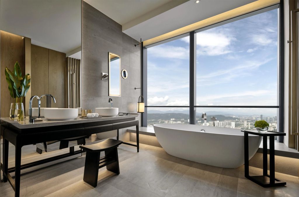 Luxuriöses Badezimmer mit freistehender Badewanne und Panoramablick auf die Stadt
