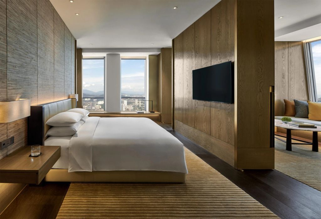 Modernes Schlafzimmer mit großem Bett und Fensterblick auf die Stadt