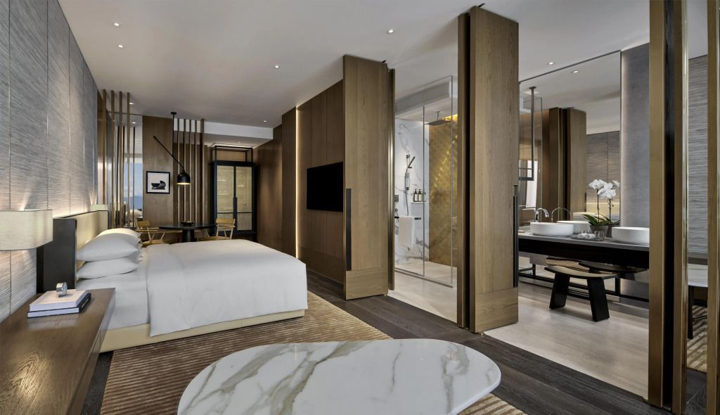Modernes Doppelzimmer mit elegantem Design und Glasabtrennung zum Badezimmer