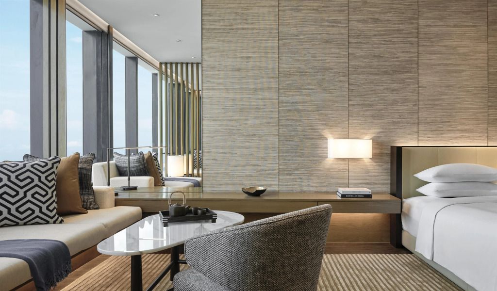 Elegante Sitzecke im Doppelzimmer mit stilvoller Beleuchtung und großem Fenster