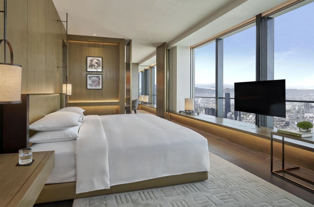 Helles Schlafzimmer mit Kingsize-Bett und großem Fenster mit Stadtblick in Kuala Lumpur.