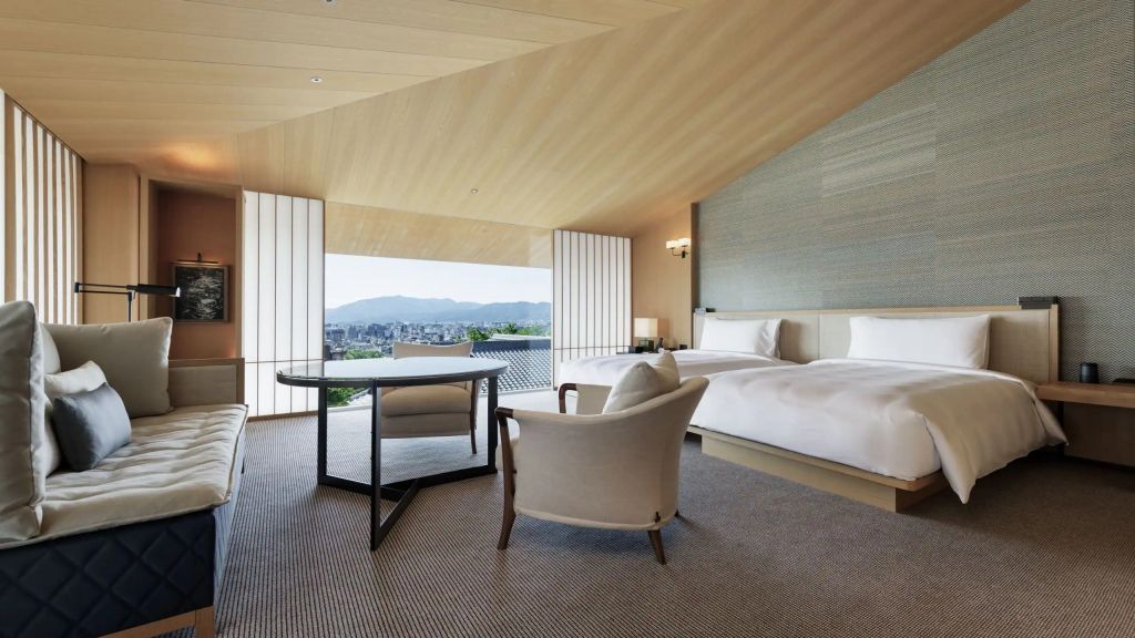 Moderne Einrichtung mit zwei Betten und Balkon mit Bergblick