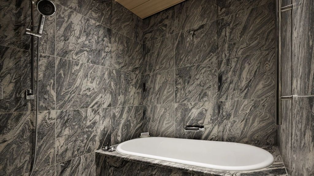 Luxuriöse Badewanne mit marmorgefliester Wandverkleidung