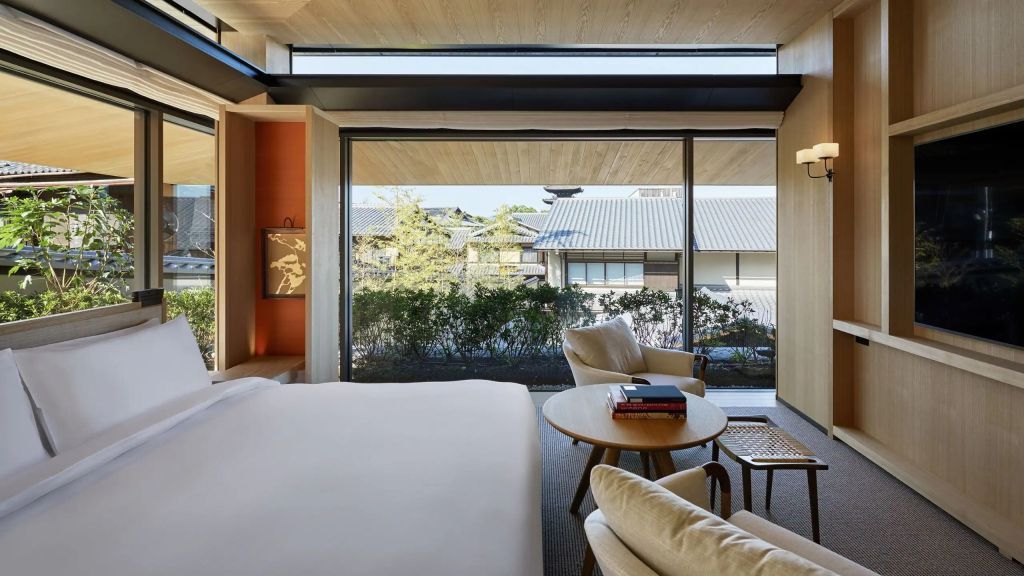 Helles Zimmer mit gemütlicher Sitzecke und Blick auf einen gepflegten Garten im Park Hyatt Kyoto