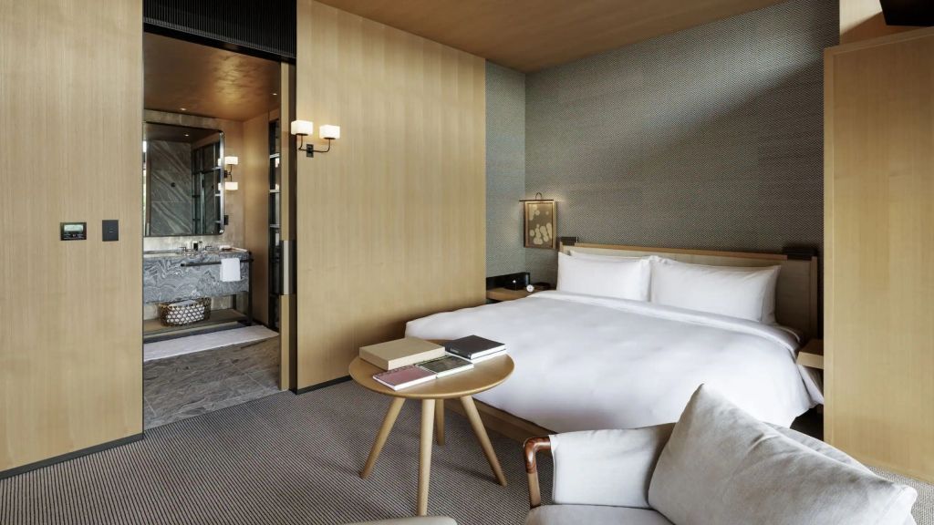 Schlafzimmer mit Doppelbett, Nachttisch und Zugang zum Badezimmer