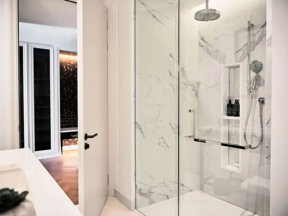 Moderner Duschbereich im Deluxe Doppel Zimmer mit Marmordesign