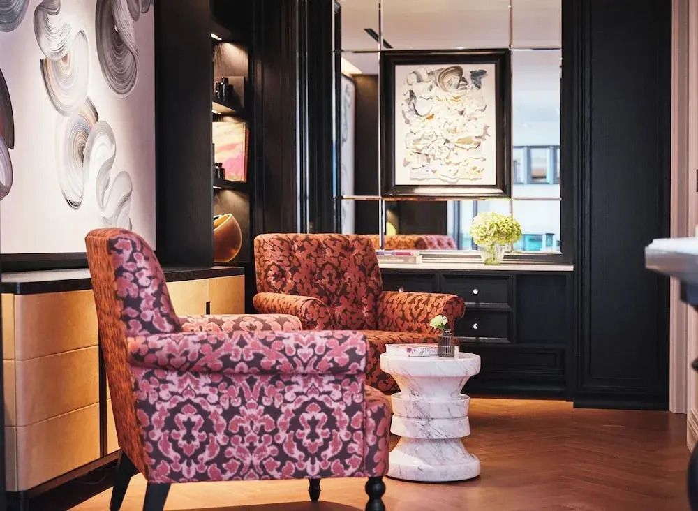 Elegantes Wohnzimmer mit zwei gemusterten Sesseln und stilvollen Dekorationen