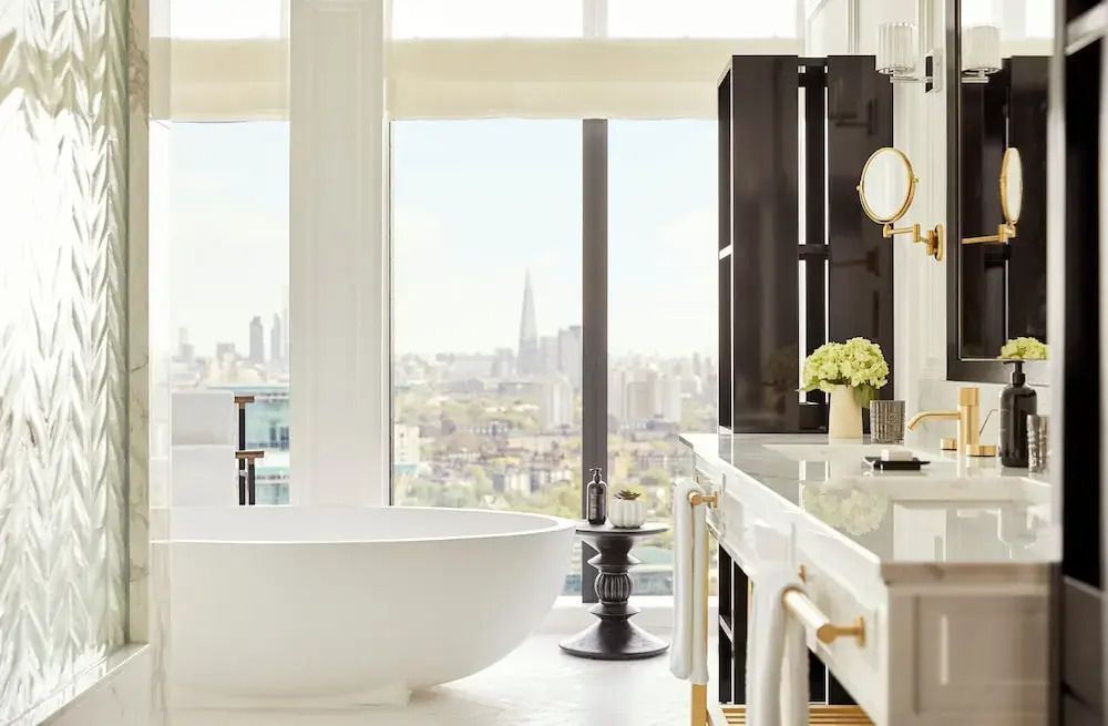 Luxuriöses Badezimmer mit freistehender Badewanne und Stadtblick